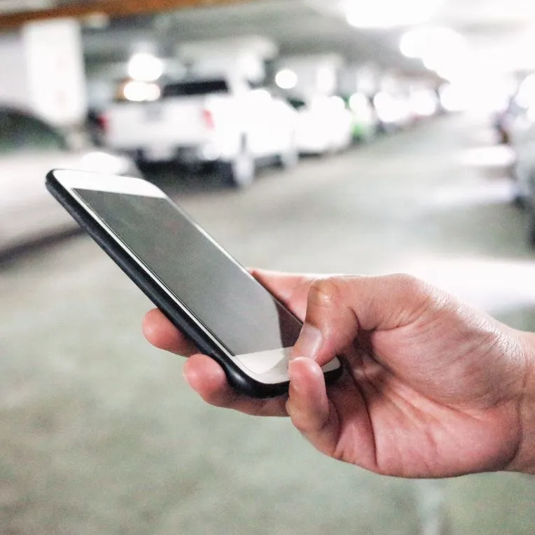 Human calling an uber ride on their cell phone.